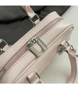 Close-up of smooth silver dual zippers on a stylish pink leather boston handbag