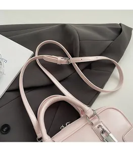 Detail of adjustable leather shoulder strap with silver buckle on pink pillow bag