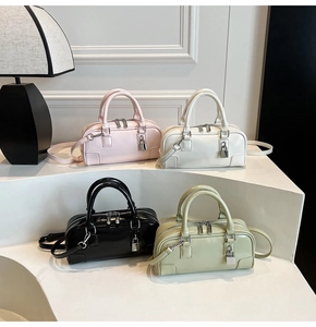 Detail showing Boston bags in pink, white, black and green with metallic lock charms