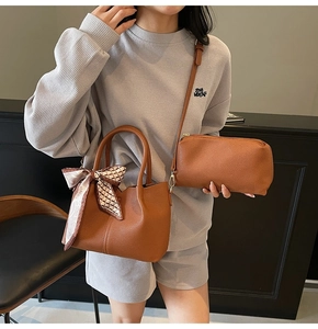 Détail du sac seau en cuir marron et sac bandoulière assorti avec foulard en soie