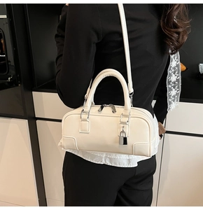 Detail of off-white Boston bag with silver padlock and adjustable shoulder strap