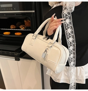 Detail of white leather Boston bag with rectangular stitching and silver lock charm