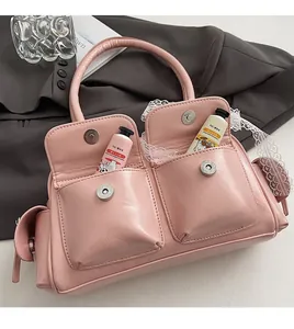 Detailed view of pink Boston bag featuring dual front pockets and silver magnetic buckles