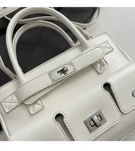 Close-up of a white vintage briefcase bag featuring a silver twist lock and fine stitching
