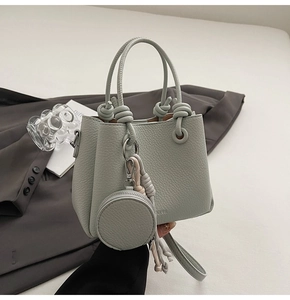 Detail of mint green lychee pattern leather bucket bag with tassel and coin purse