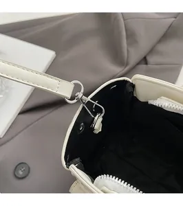 Detail of silver metal lobster clasp and zipper on white commuter briefcase handbag