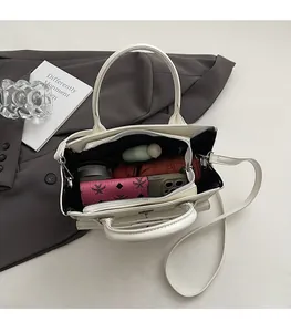 Interior view of white tote bag showing spacious capacity for phone, wallet and cosmetics