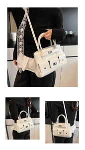 Detail of white multi-pocket satchel with silver twist locks and lace silk scarf detail