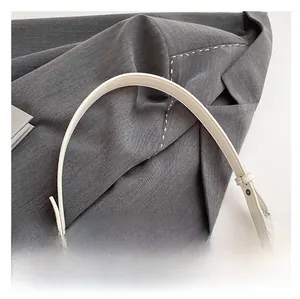 Détail de la bandoulière réglable en simili cuir blanc avec clous en métal argenté