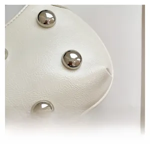 Détail du cuir plissé blanc crème avec des rivets sphériques argentés brillants