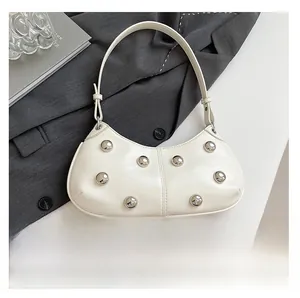 Vue détaillée d'un sac à bandoulière blanc avec clous argentés et référence de téléphone