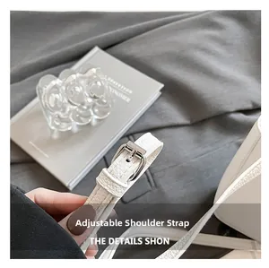 Detail showing adjustable pebbled leather shoulder strap with silver buckle hardware
