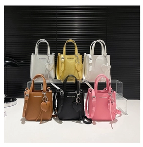 Multiple colors of lychee grain bucket bags with heart charms and adjustable straps