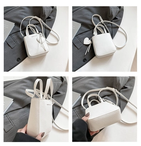 Detailed views of a white lychee leather mini bucket bag with heart charm and shoulder strap