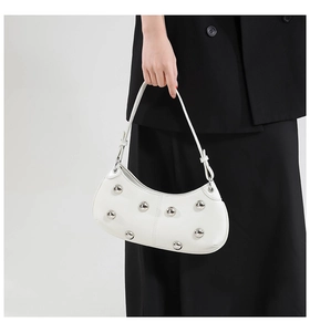 Détails du sac demi-lune blanc avec rivets argentés et texture en cuir lisse