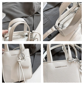 Detail view of white lychee pattern bucket bag with heart pendant and metal zipper