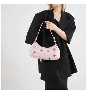 Détail du sac en cuir verni rose orné de gros rivets sphériques argentés brillants