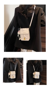 Detail of minimalist beige crossbody phone bag with tassel and plush ball charm on stairs