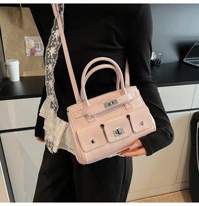 Detail of pink PU leather tote with three buckled exterior pockets and silver metal studs