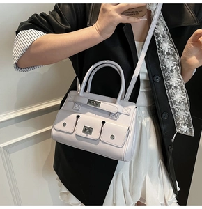 Detail of the multi-pocket construction and silver twist-lock on this lilac handbag
