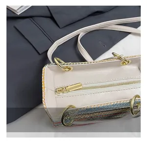 Détail de la fermeture éclair dorée et de la quincaillerie sur le sac à main tissé