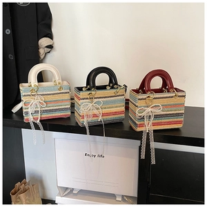 Détail de sacs à main tissés colorés avec breloques en dentelle perlée et poignées