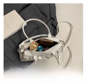 Internal view of the white handbag showing capacity for phone and perfume accessories