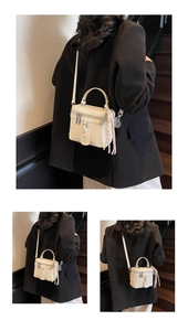 Détail du sac boîte en cuir litchi blanc avec ferrures argentées et pompon bicolore