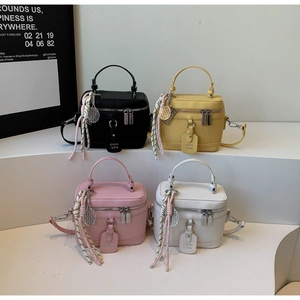 Détail de quatre sacs boîtes colorés avec texture litchi et pendentif de raquette