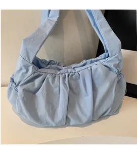 Detail showing the pleated texture and soft fabric of this light blue crossbody bag