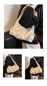 Close-up of beige ruched cloud bag with wide shoulder strap and modern pleated details