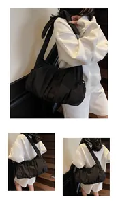 Detail view of large black pleated shoulder bag with wide strap for daily commuting