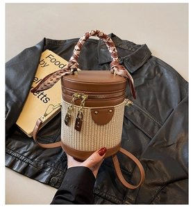 Detail of cylinder bag featuring woven texture, silk scarf handle, and gold hardware accents