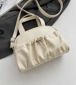Detail showing cream pleated PU leather surface with metal buckle and drawstring decor