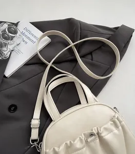 Detail of creamy white crossbody bag with side pleated texture and silver hardware