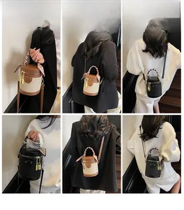 Detail view of cylinder bucket bag with silk scarf handle and leather texture