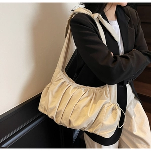 Detalle del bolso nube plisado blanco crema con textura suave y correa ancha para el hombro