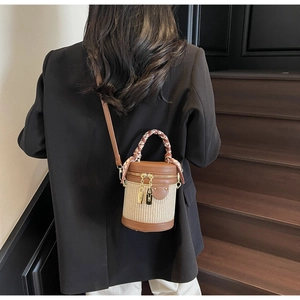 Rear view of model with woven cylinder bucket bag featuring brown leather trim and scarf
