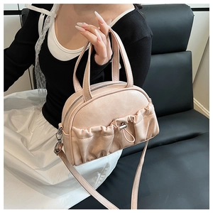 Close-up of pink pleated handbag with silver metallic zipper and premium PU leather texture