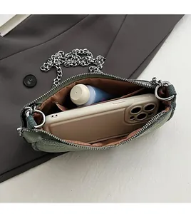 Detail view of denim crossbody bag interior showing storage for phone and cosmetics