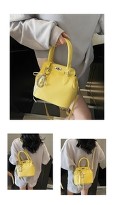 Detail of yellow pebbled leather Kelly handbag with pearl chain and silk ribbon decor