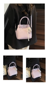 Detailed macro view of a light purple leather handbag featuring a pearl and ribbon charm