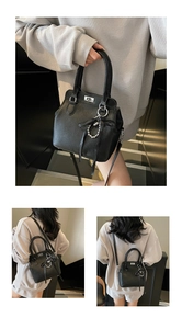 Detail of black lychee grain leather bag with silver twist lock and bow chain charm
