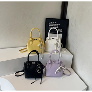 Detail of four colorful leather milk box bags with top handles and metallic turn-locks