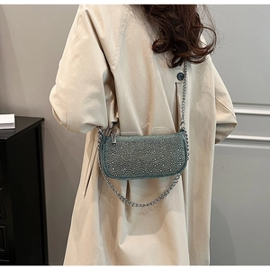 Detail of teal denim bag with sparkling rhinestones and silver chain strap