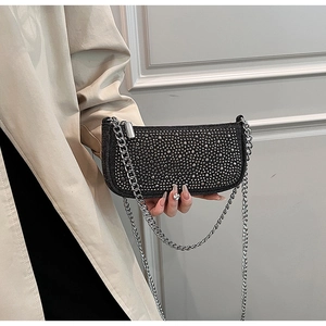 Close-up of elegant black handbag with silver rhinestones and chunky metal chain strap