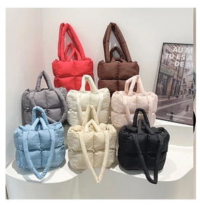Nahaufnahme von gesteppten Puffer-Taschen in acht Farben mit Nylon-Struktur und Gurten