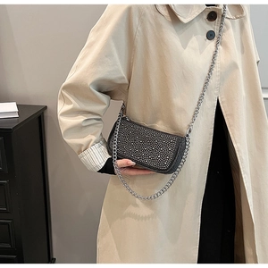 Detail of black rectangular crossbody bag with shimmering silver rhinestones and chain strap