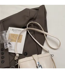 Dettaglio di una borsa a secchiello in pelle bianco crema con fibbia in argento chic