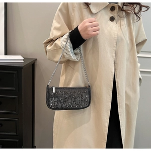 Detail of black denim bag with sparkling rhinestones and silver chain strap for women